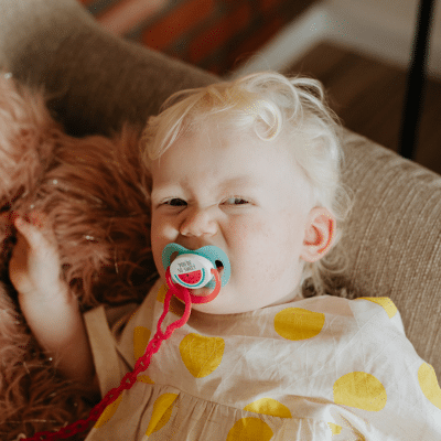 Little kid with a pacifier in her mouth, representing how pacifiers affect teeth