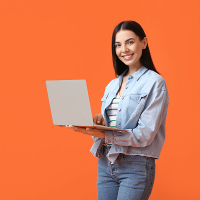 A woman standing and smiling, holding a laptop, representing wilmington pediatric dentistrys new website