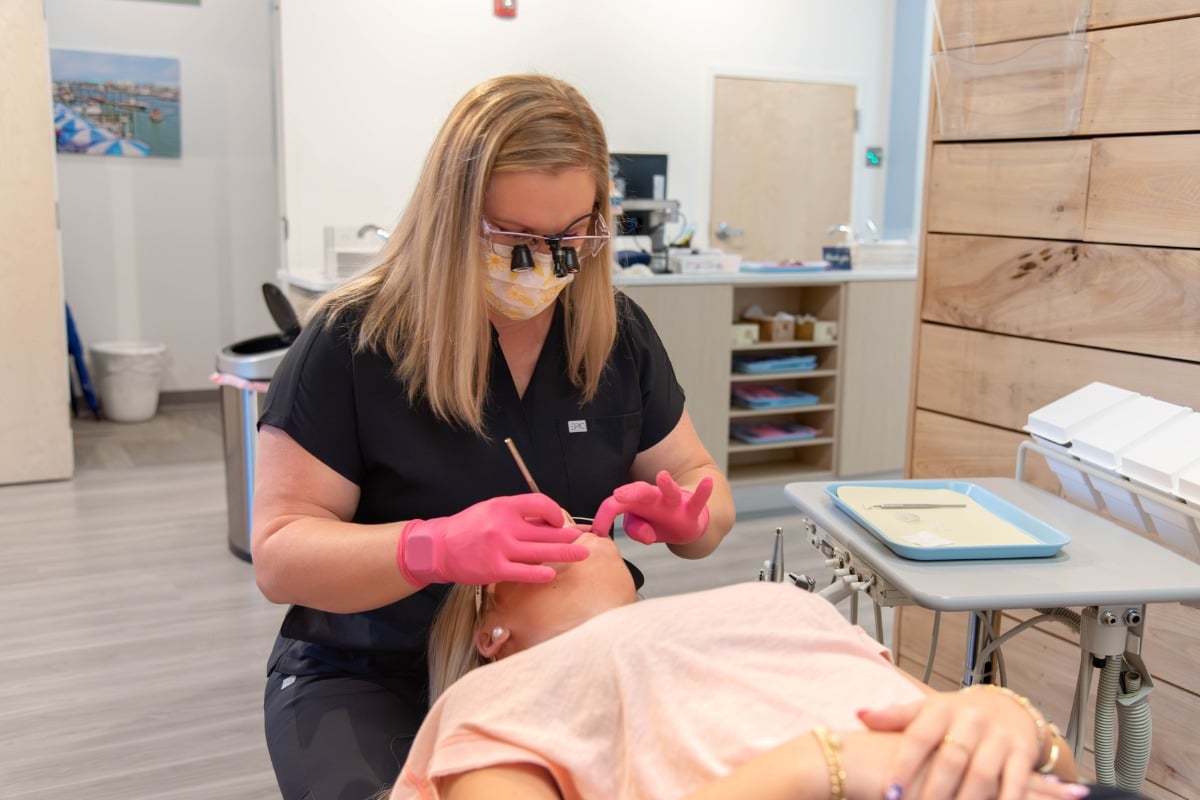 Pediatric dental hygienist providing gentle restorative care to a young patient.