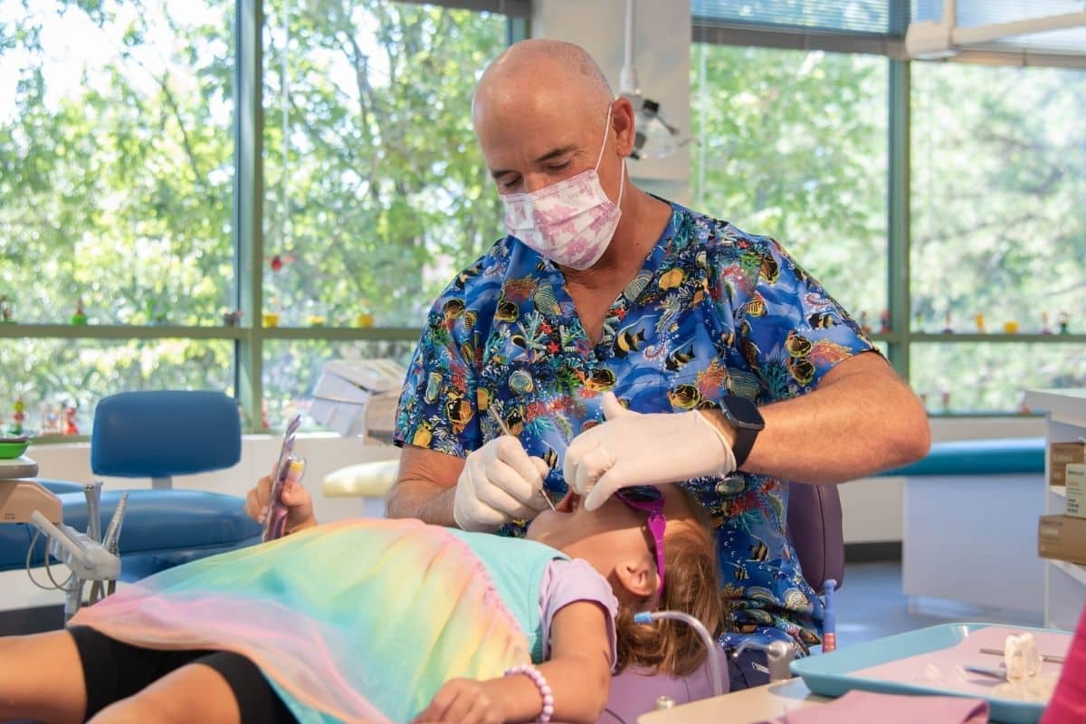 Pediatric dentist treating a young patient during a dental exam at Wilmington Pediatric Dentistry in Wilmington, North Carolina.